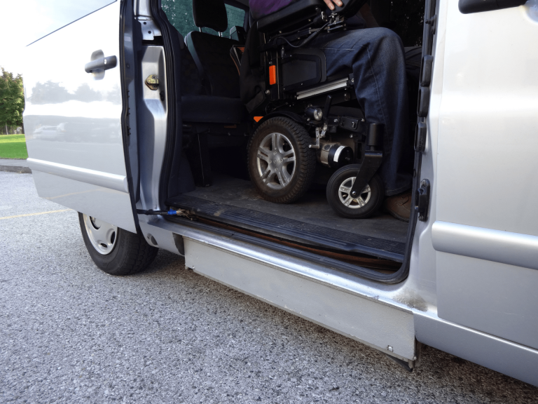 personne en fauteuil roulant qui est à bord d'un taxi pour personnes à mobilité réduite