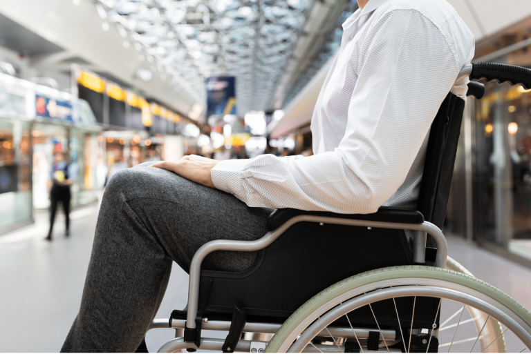 homme en fauteuil roulant qui attend son transport pour personnes à mobilité réduite