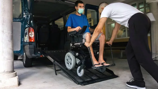 personne en fauteuil roulant qui est utilise une voiture adapté au transport de personnes à mobilité réduite avec rampe d'accès